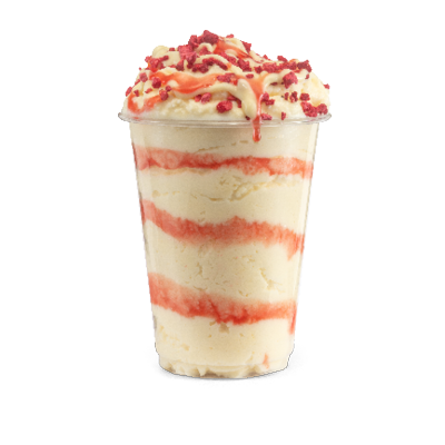Creamy soft serve ice cream sundae swirled with strawberry and white chocolate sauce topped with fruity crumb